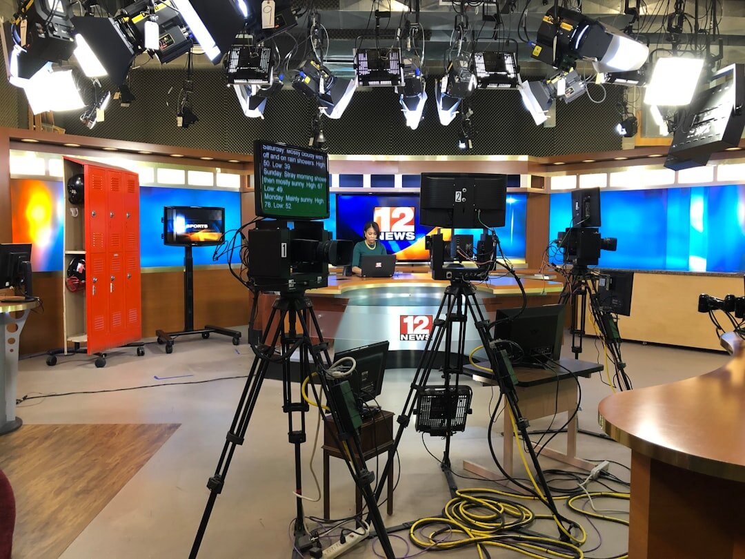 Modern newsroom with journalists working at computers and screens